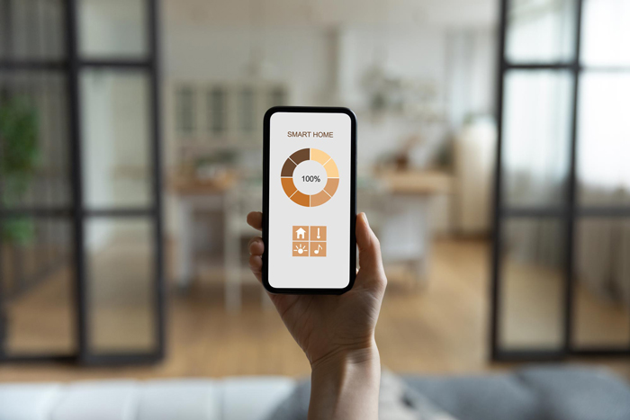 Close up back view of woman hold modern cellphone use smart home application on gadget screen